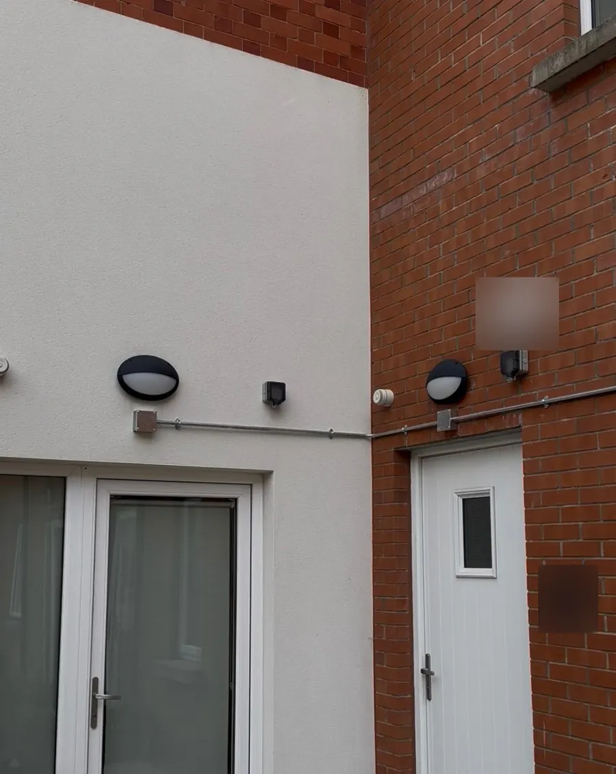 Conduit run along an external wall between entrances